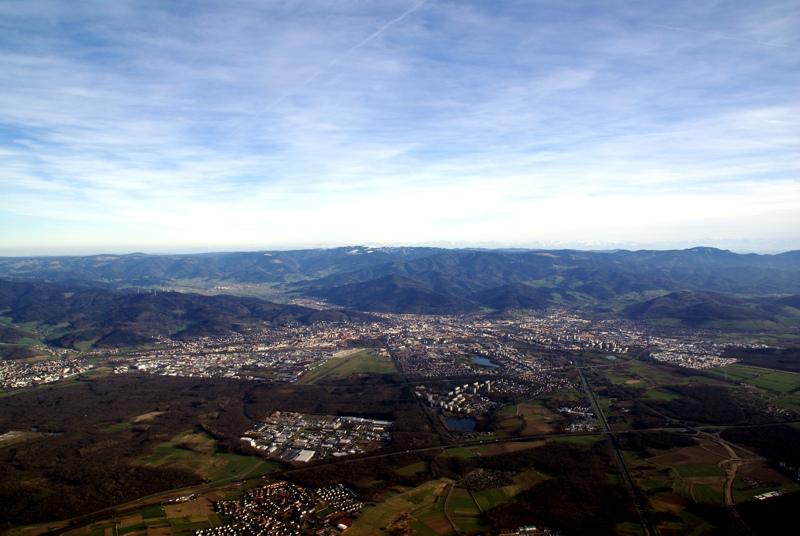 Blick aus dem Ballonkorb über der March nach Freiburg und über den Schwarzwald bis zu den Alpen